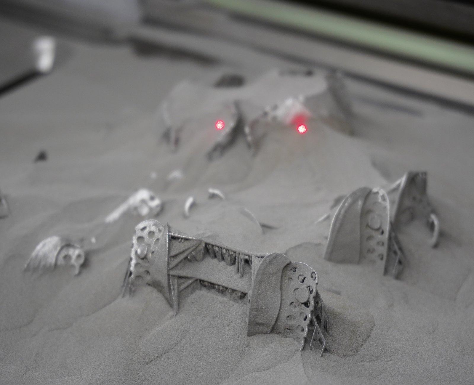 Printed frameworks rising out of the powder bed, laser still on
